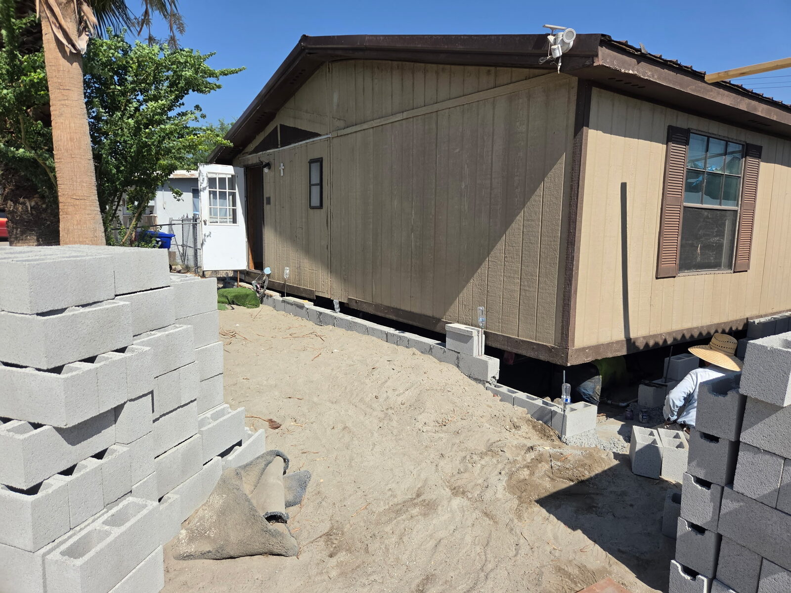 Cinder block piers being placed under a mobile home